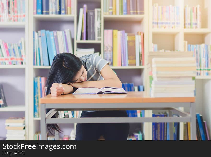 Portrait of clever Asian student exhausted for reading