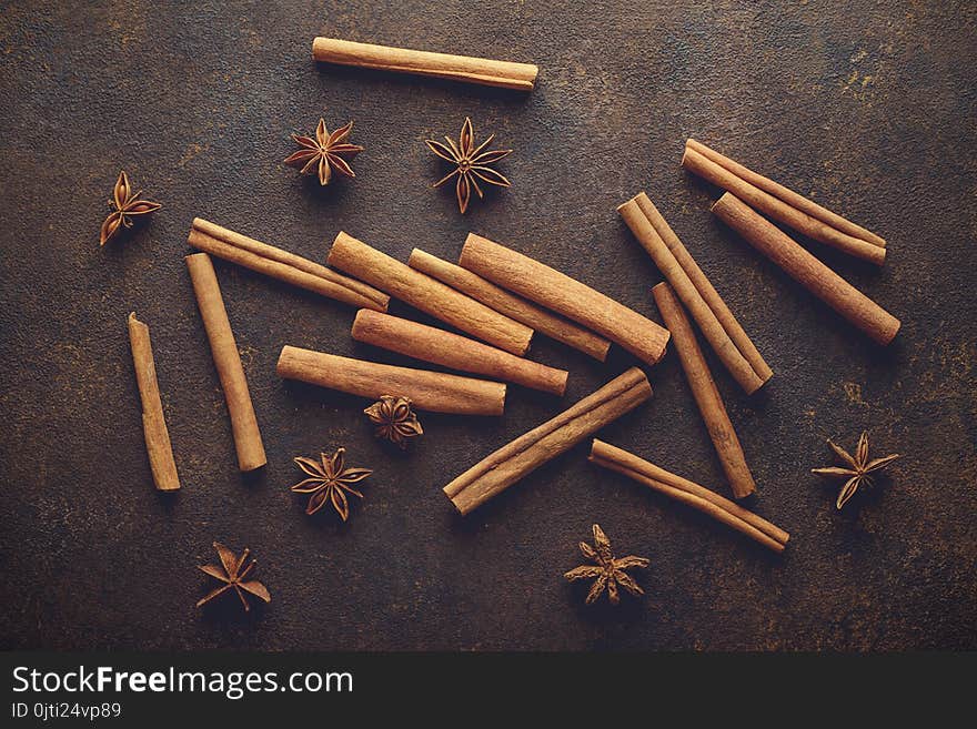 Cinnamon sticks and anise stars on the brown rusty backround top view.