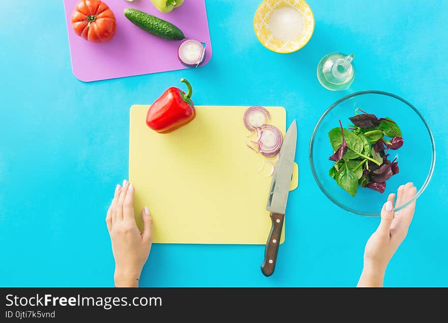 Healthy food concept. Diet food. Woman hands cooking summer vegetarian salad on blue background. Healthy food concept. Diet food. Woman hands cooking summer vegetarian salad on blue background