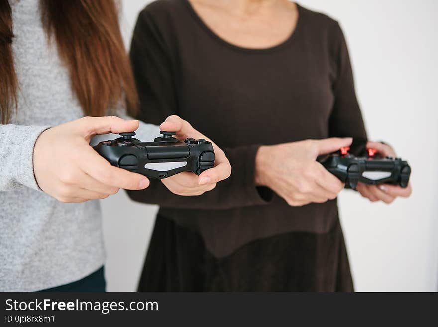 A young girl and an elderly woman play together in a video game. Joint pastime. Family life. Communication of the grandmother with her granddaughter