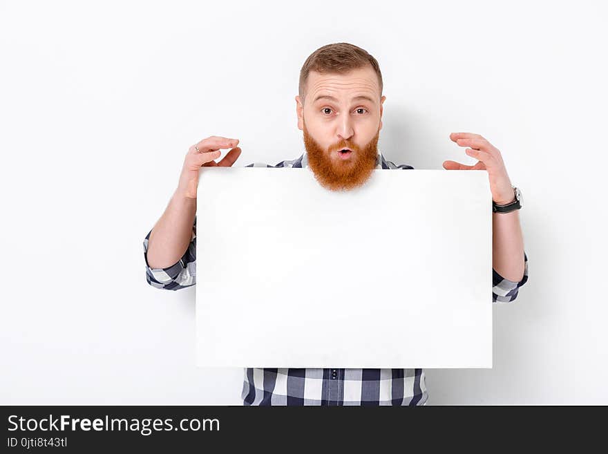 Handsome man with beard holding big white card. empty blank board