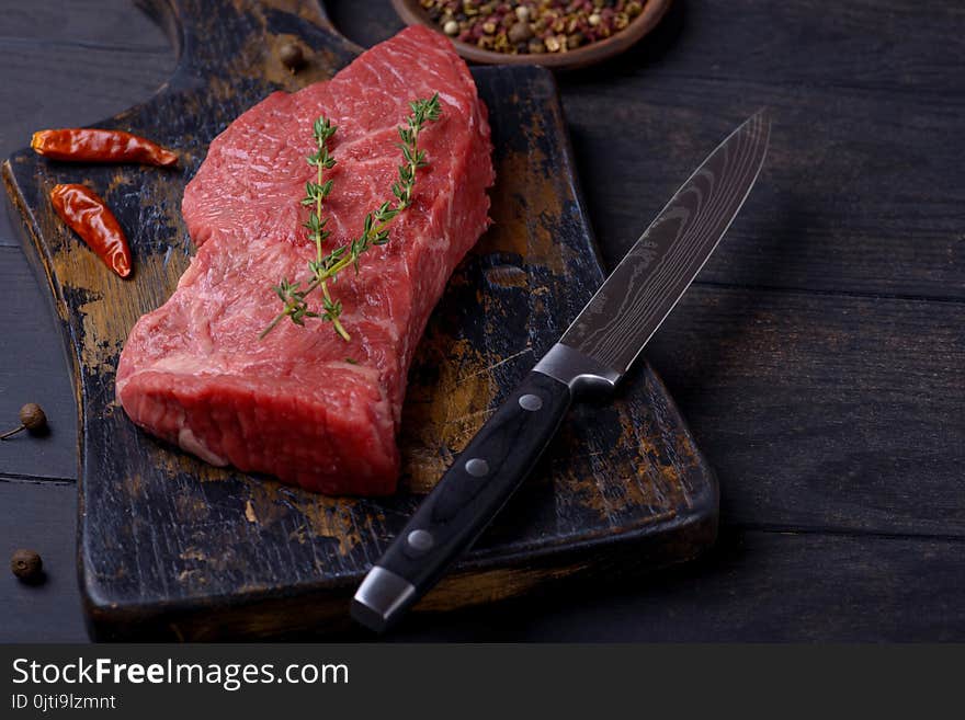 Raw Beef Steak With Thyme And Pepper And Knife