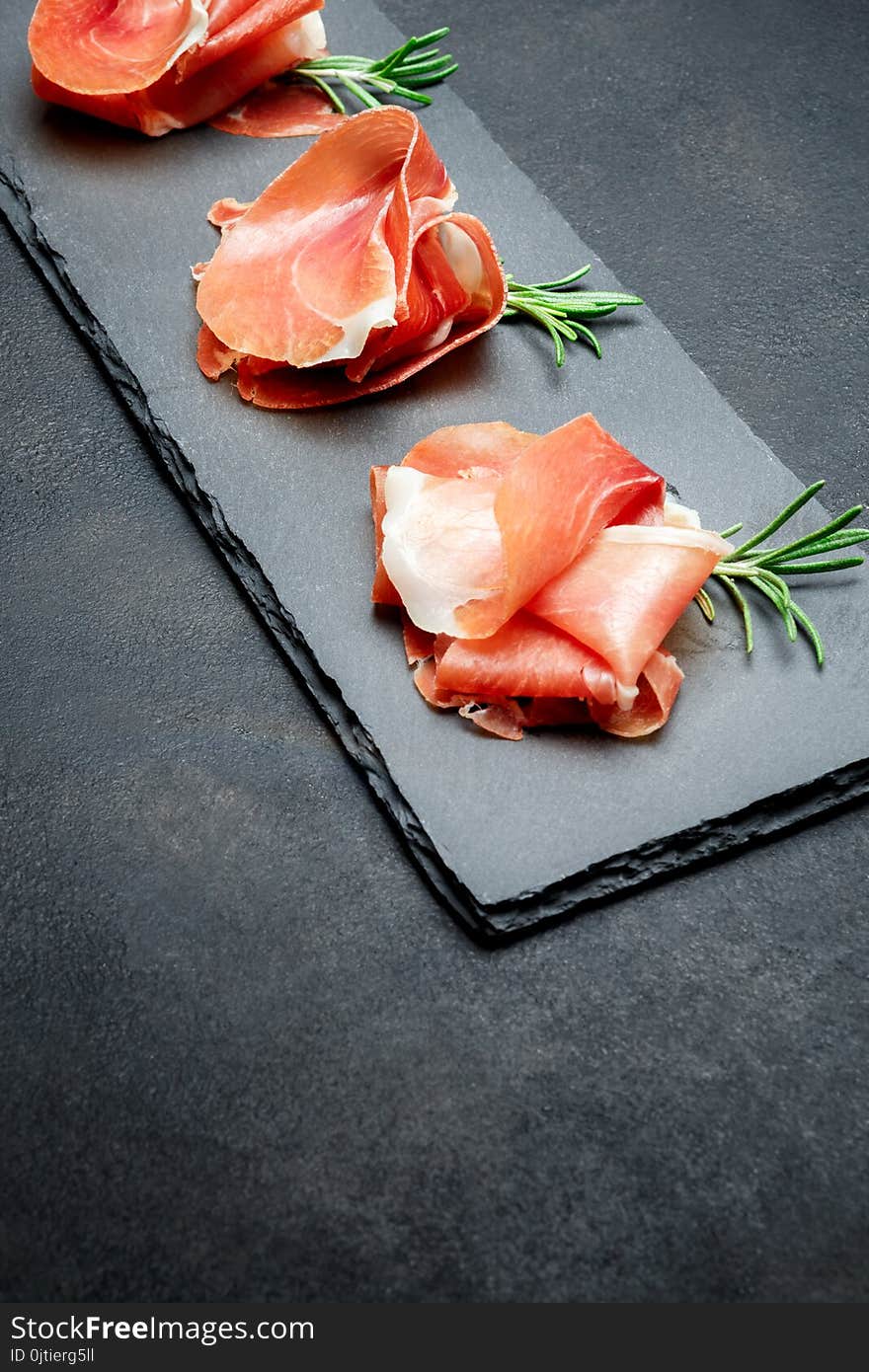 Italian prosciutto crudo or spanish jamon. Raw ham on stone cutting board