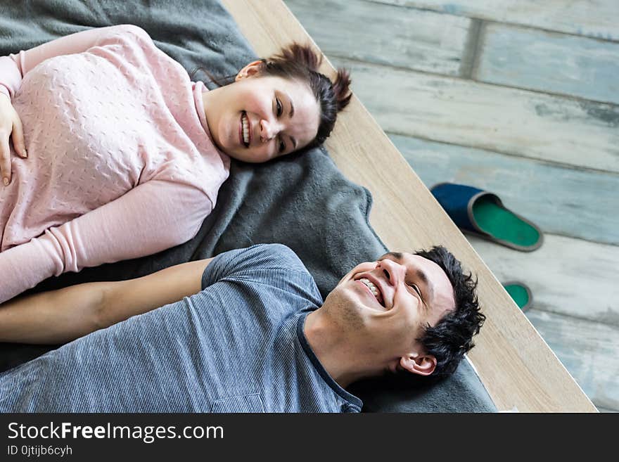 Romantic couple. Beautiful young loving couple embracing while lying on big cozy bed at home. Romantic couple. Beautiful young loving couple embracing while lying on big cozy bed at home.