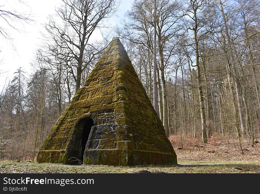 Ancient stone pyramid with moss in the forest on the way to the World Cultural Heritage Herkules in Kassel, Wilhelmshöhe, Germany