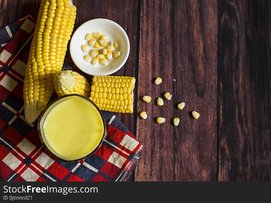 Fresh Corn And Milk On Cobs On Wooden Table, Closeup.