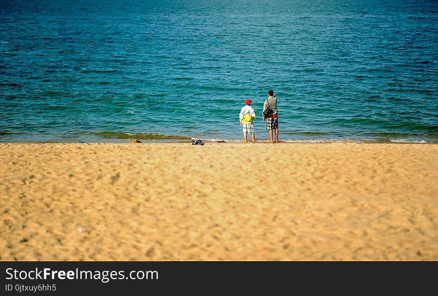 Two Persons Standing Near Beach