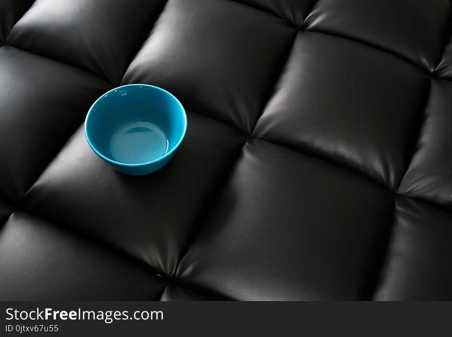 Blue Ceramic Bowl on Black Leather Surface