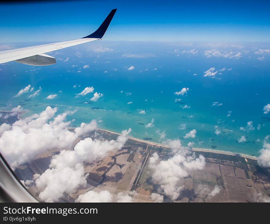 Shot of beach taken from airplane, wing in the corner, high aerial view