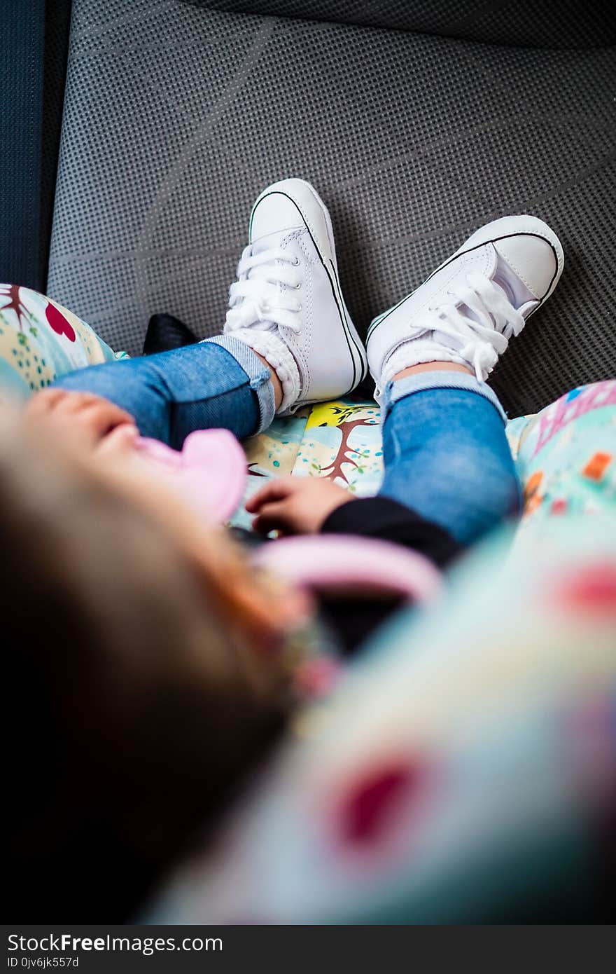 Cute white shoes on baby girl, detail, blurred