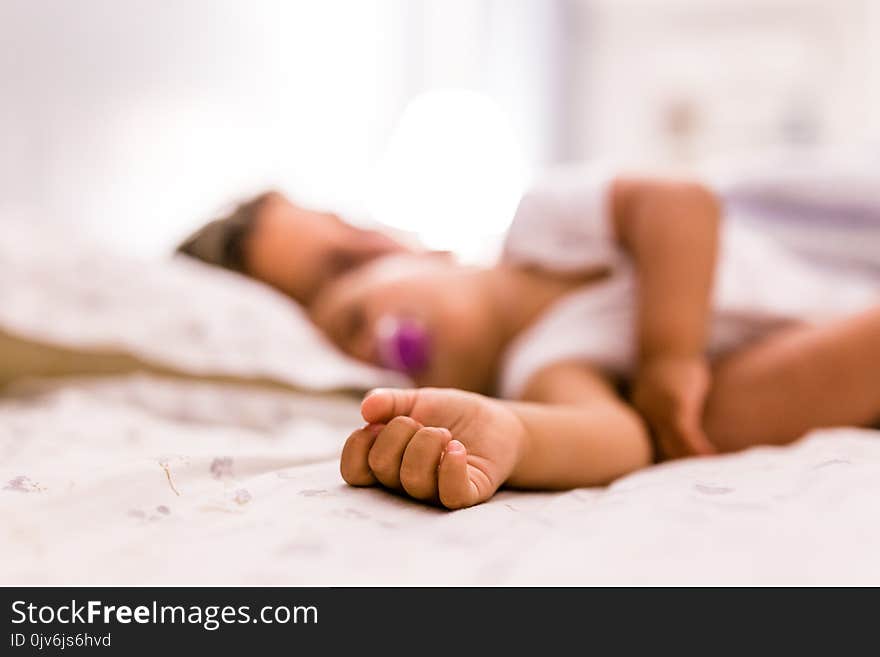 Cute hand of baby girl sleeping with her mother, detail, blurred, love