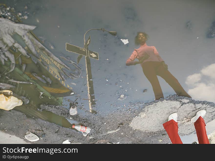 Woman Standing on Ground Surrounded With Water