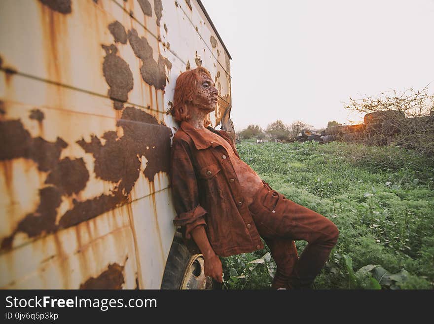 Man Wearing Brown Button-up Jacket and Pants Leaning on Wall