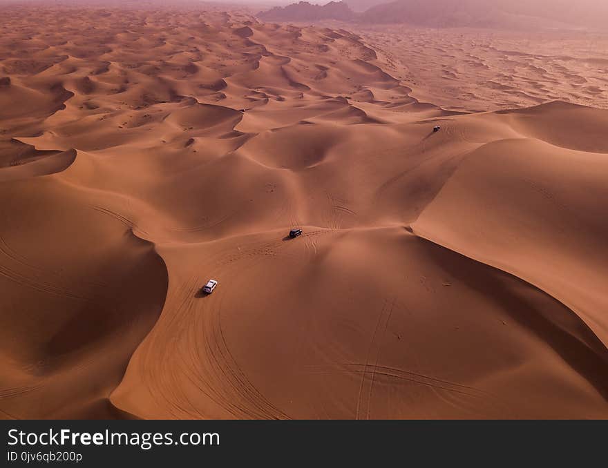 Two Vehicles on Desert Dunes