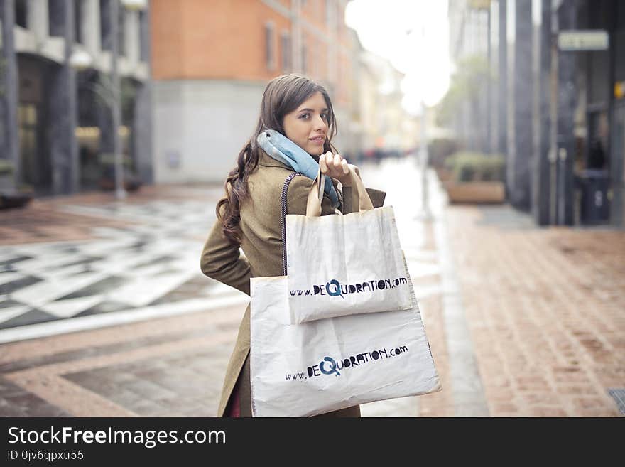 Woman in Brown Coat Carrying Two White Tote Bags