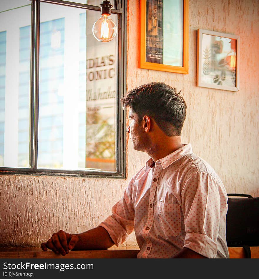 Man Wearing White and Red Dress Shirt Staring Outside Window