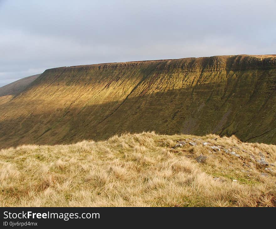 Photo of Gray Grass Field Across Hill