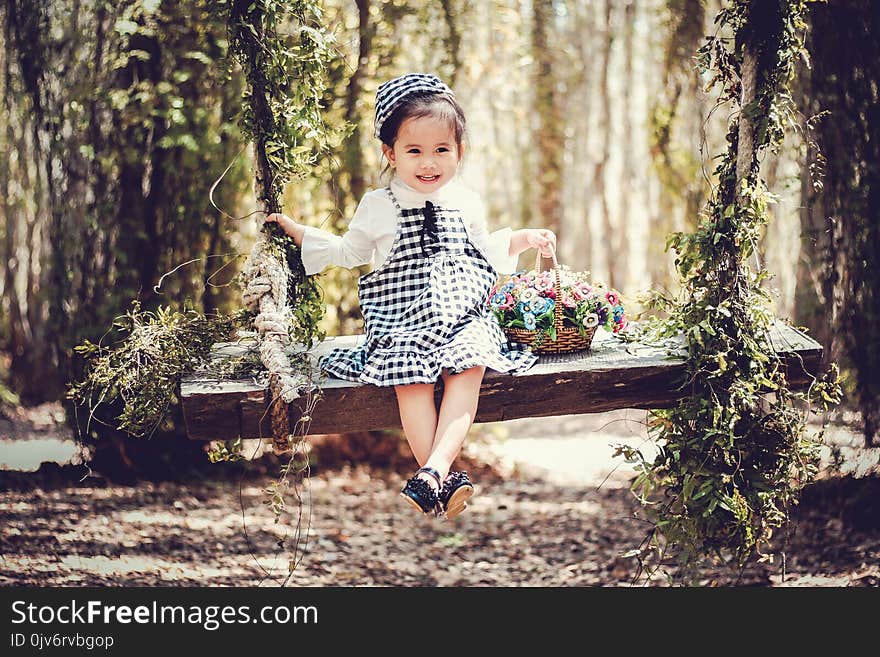 Girl in Black and White Overall Skirt Holding Basket With Petaled Flowers