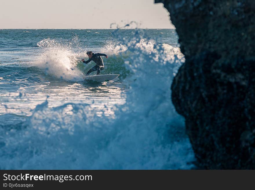 Man Surfing on Body of Water