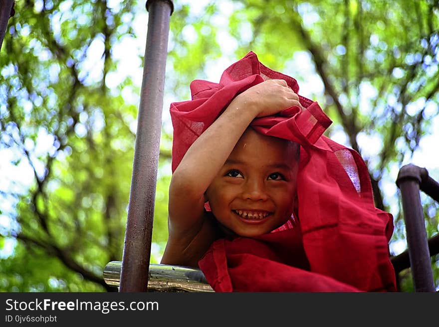 Boy Holding Red Textile Covering His Head