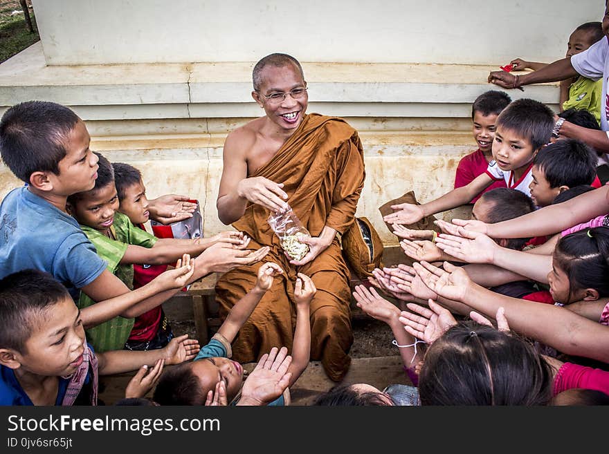 Man in Monk Dress Between Group of Children