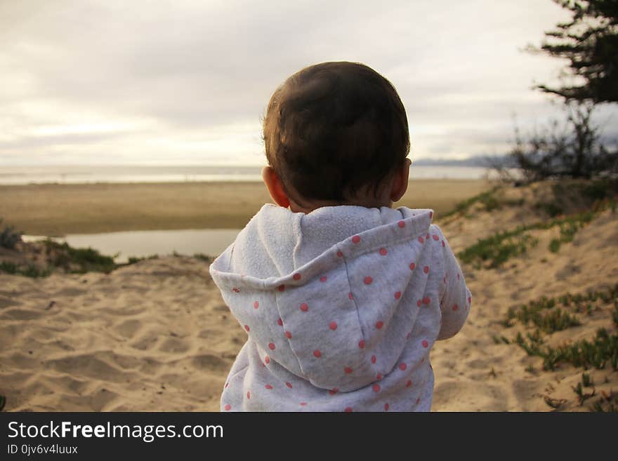 Baby spending time playing with toys on the beach. Child plays in the sand. Fun time for a family on the beach. Baby spending time playing with toys on the beach. Child plays in the sand. Fun time for a family on the beach.