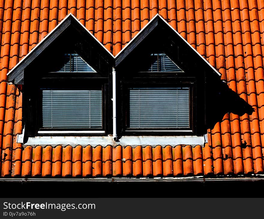 Double Dormers with brown clay pitched roof and metal gutter. metal snow guard and ice breaker. frontal elevation view. strong shadow. summer lights.