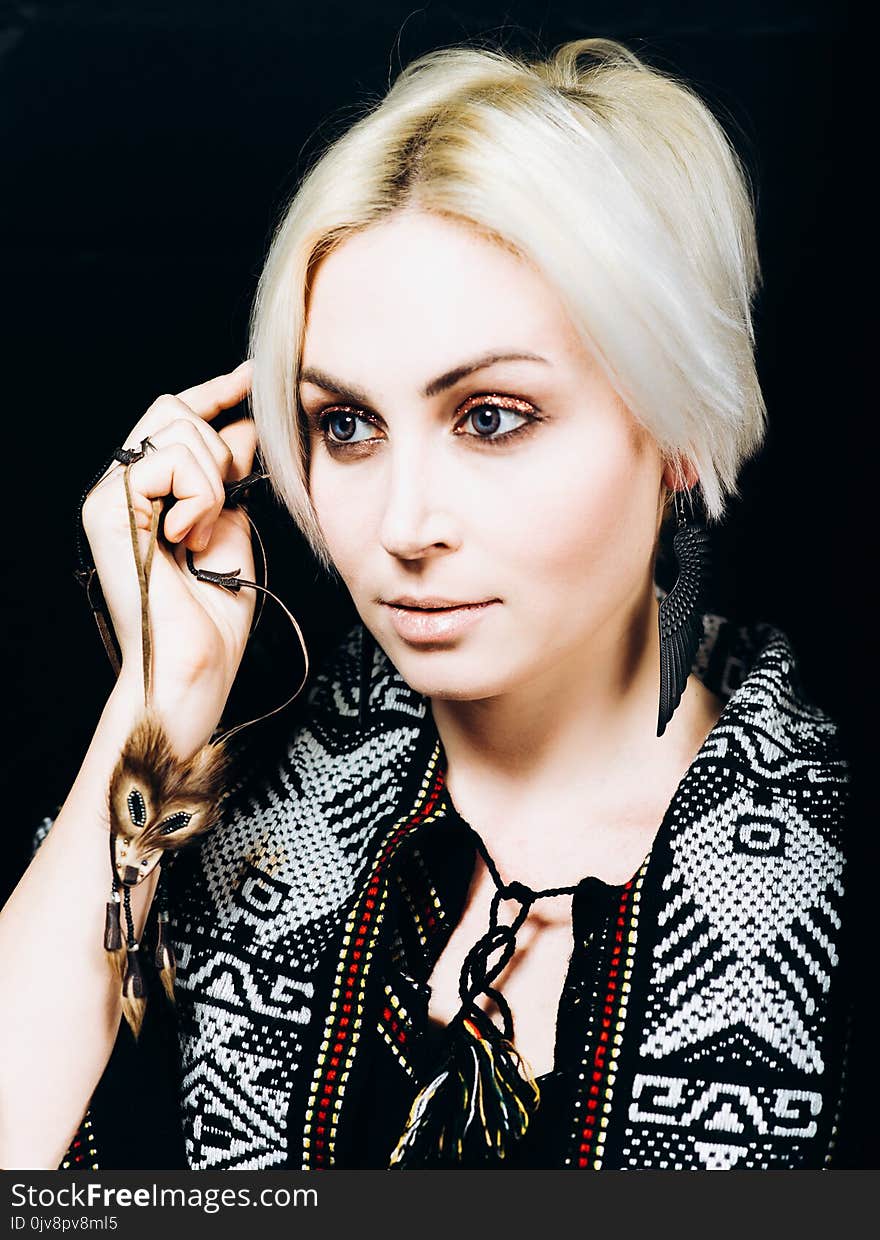 A portrait of a young pretty blonde on a black background in studio. A portrait of a young pretty blonde on a black background in studio