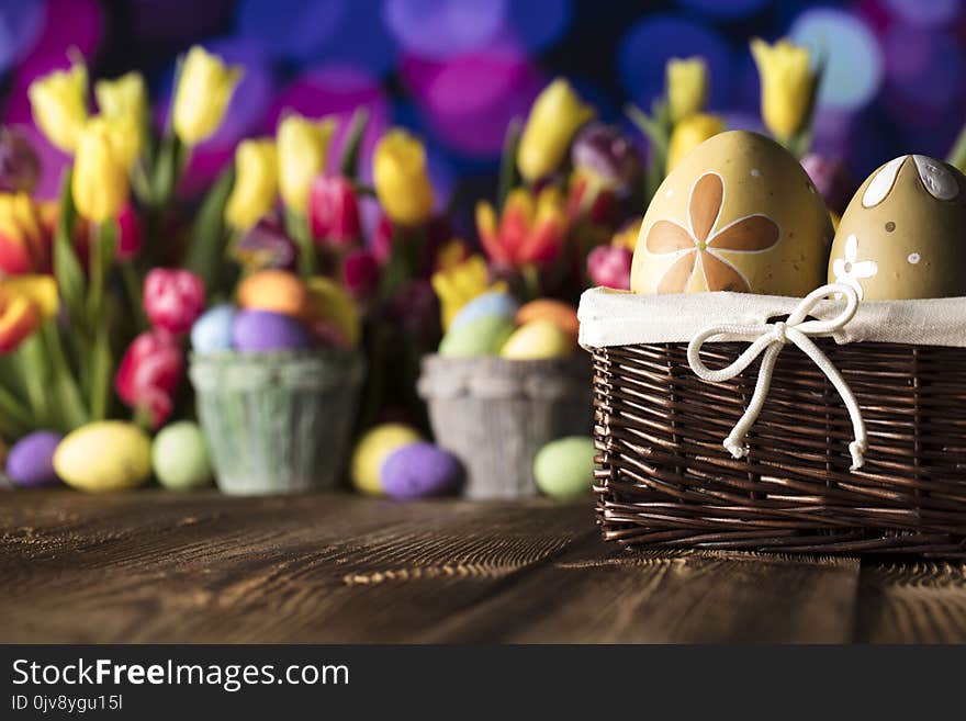 Easter eggs and tulips on wooden rustic table. Blue bokeh background. Easter eggs and tulips on wooden rustic table. Blue bokeh background.