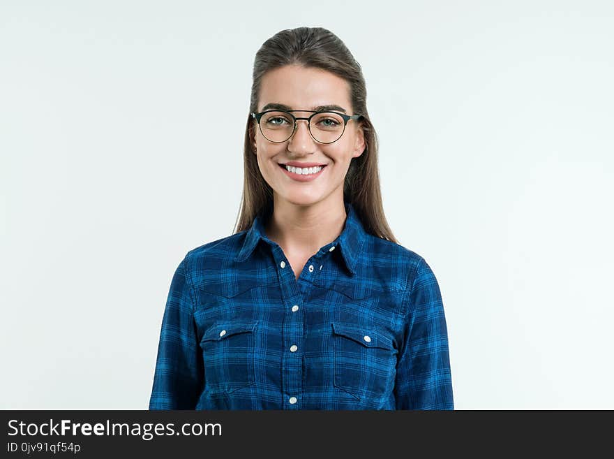 Portrait of young positive woman with long straight hair, blue eyes and an attractive smile, posing in the studio on white background. People, happiness, emotions and way of life