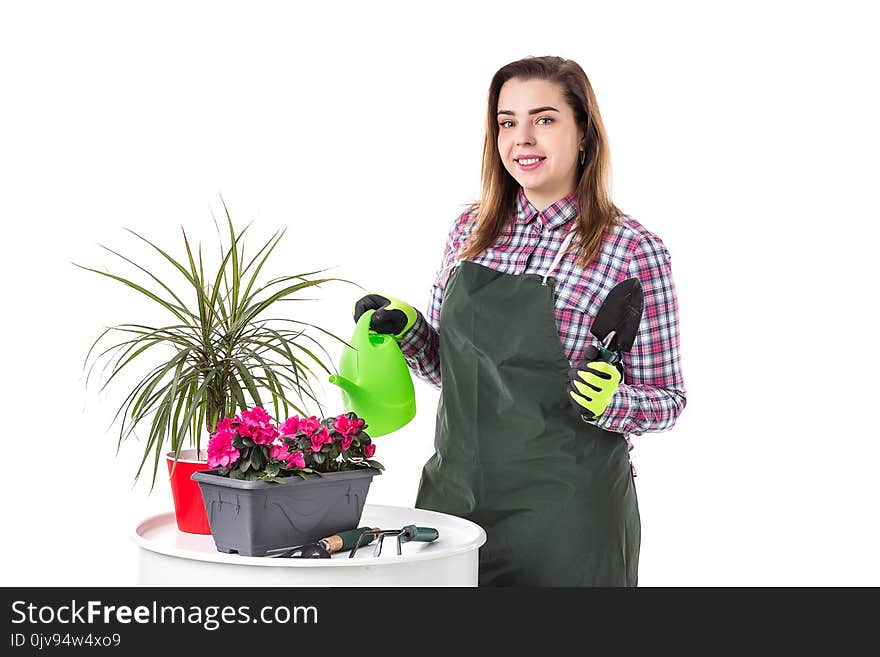 Portrait of smiling woman professional gardener or florist in apron holding flowers in a pot and gardening tools isolated on white background