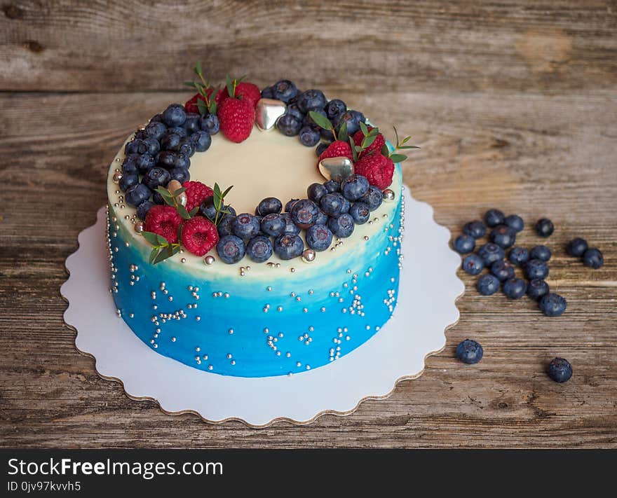 Home pale blue cake with blueberries and raspberries