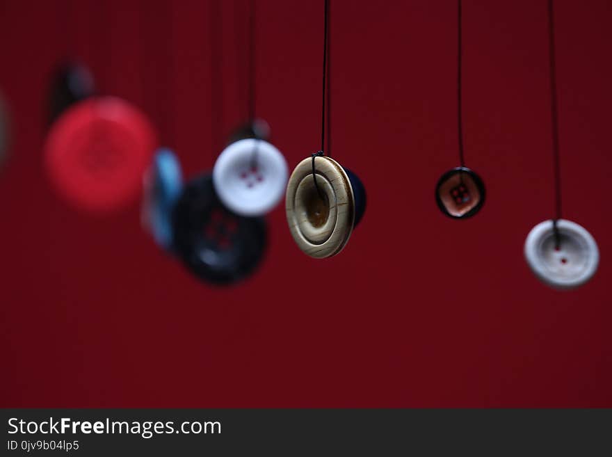 Variety of buttons and thread, different colors and sizes, red background, copyspace. Variety of buttons and thread, different colors and sizes, red background, copyspace