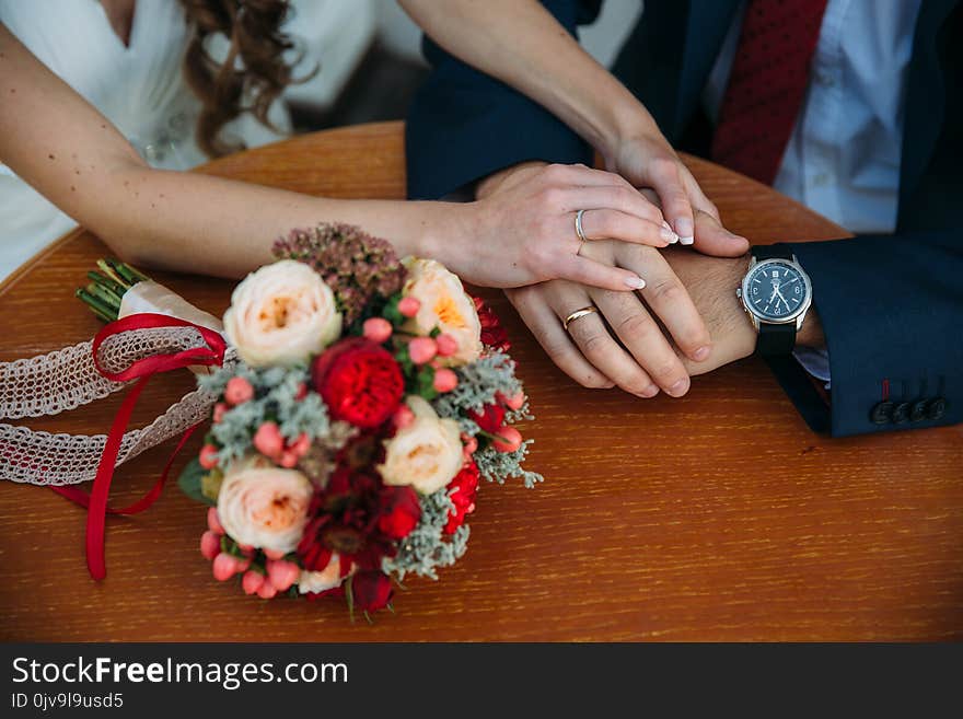 Closeup groom and bride are holding hands at wedding day and show rings. Concept of love family.