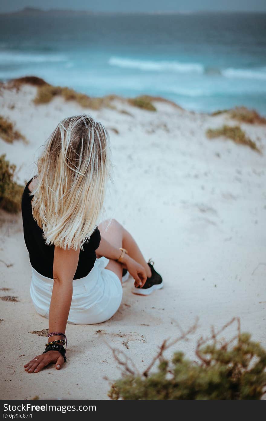 Woman sitting in snow-white dune landscape on the Atlantic coastline. Sao Vicente Cape Verde