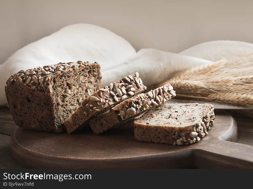 A loaf of fresh rustic rye bread on wooden board. Healphy food background. Close up. Copy space. Fitness wholegrain