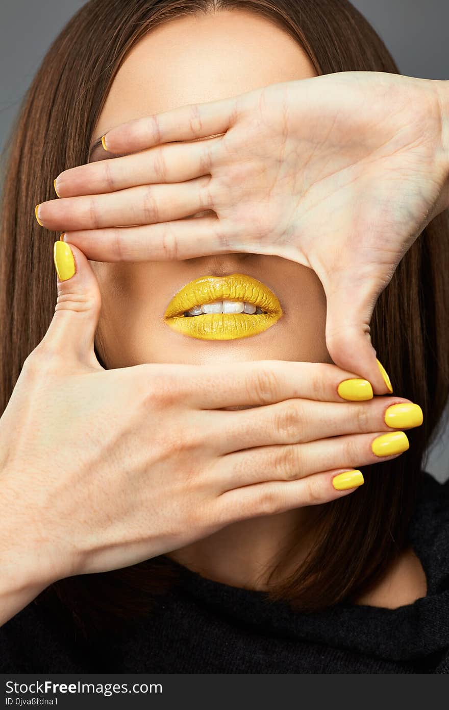 Woman face. Yellow nail. Blue lips. Close up Isolated beauty portrait.