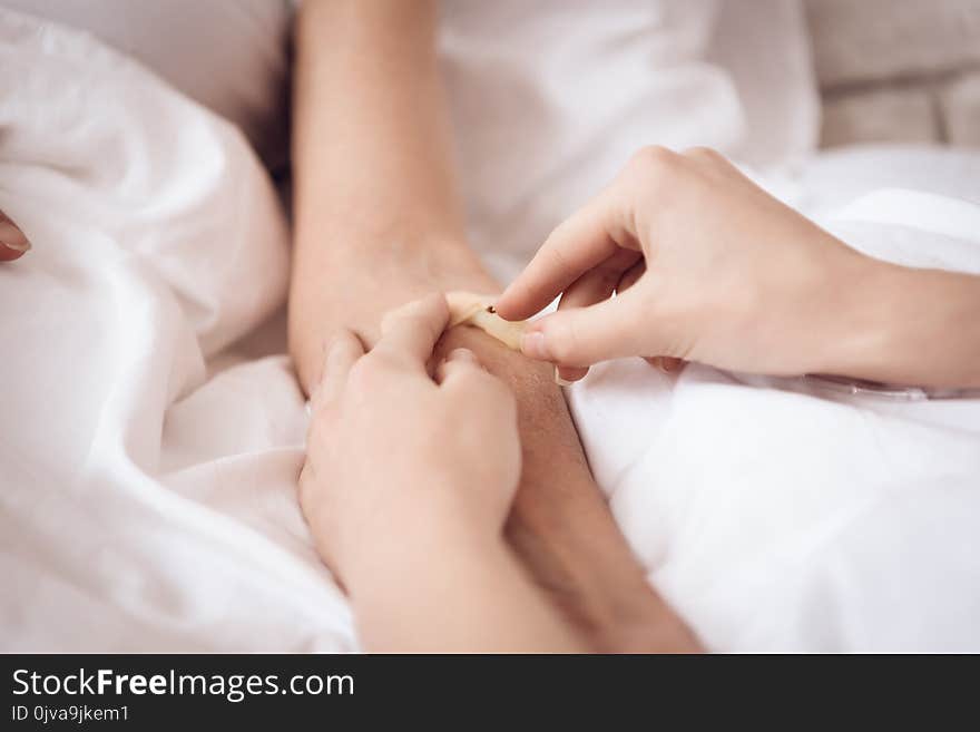 Close Up. Girl Is Nursing Elderly Woman At Home. Girl Is Putting Drop Counter Needle.