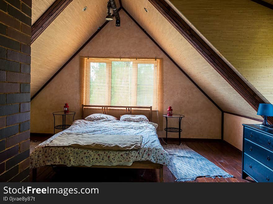 Interior of a room with a bed on the top floor of a wooden house