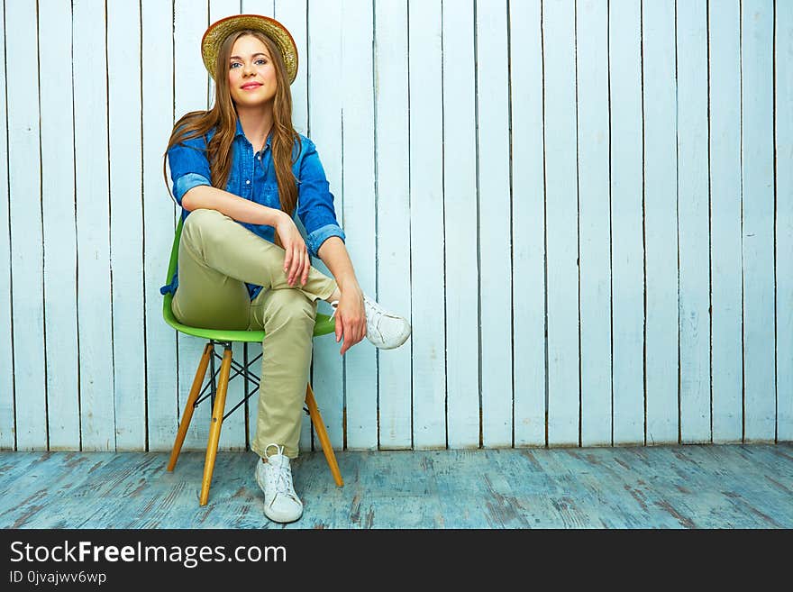 Hipster style young woman sitting on chair.