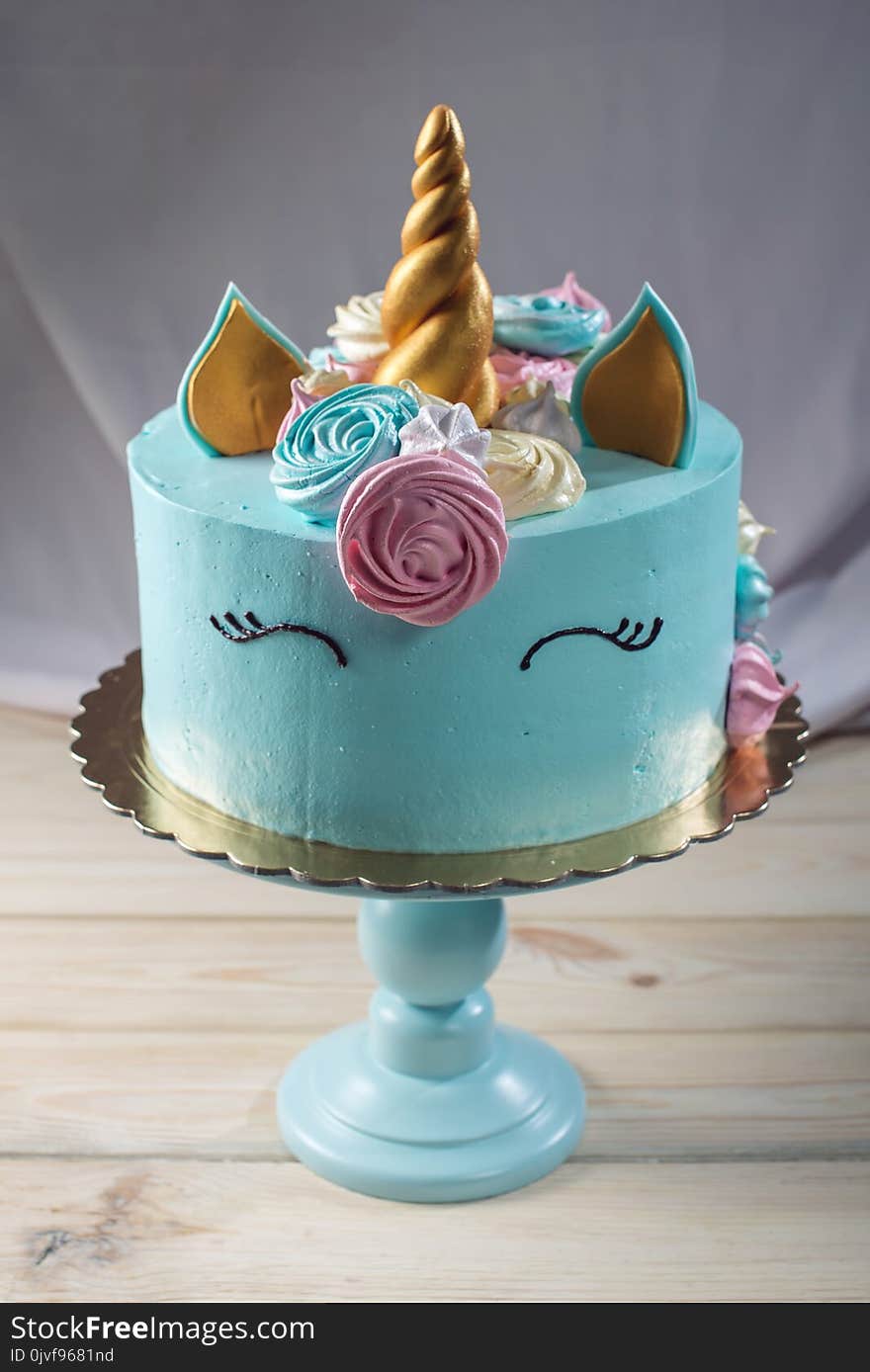 A beautiful bright cake decorated in the form of fantasy unicorn in the blue bookcase. The concept of a festive dessert for kids birthday. A beautiful bright cake decorated in the form of fantasy unicorn in the blue bookcase. The concept of a festive dessert for kids birthday