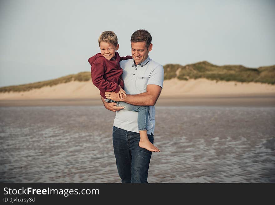 Father and son spending some time together, walking down the beach on holiday. Father and son spending some time together, walking down the beach on holiday.