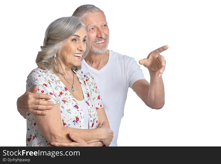 Portrait of hugging senior couple pointing isolated on white background