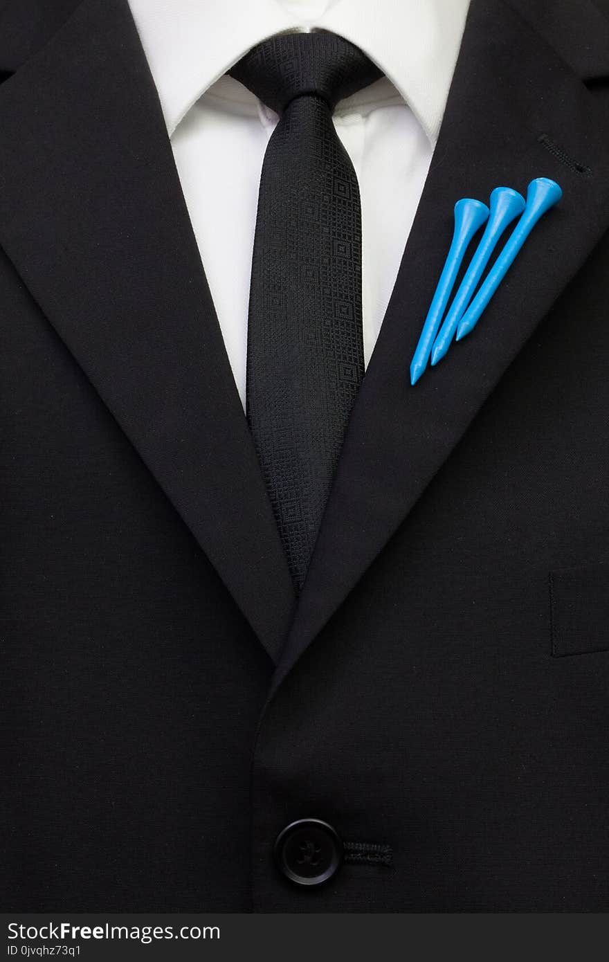 The detail of wedding suit with golf design. Blue golf tees on the flap of black jacket.