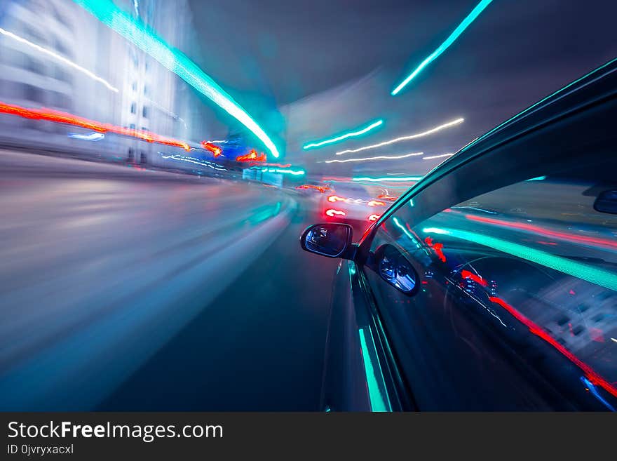 View from Side of Car moving in a night city, Blured road with lights with car on high speed. Concept rapid rhythm of a modern city.