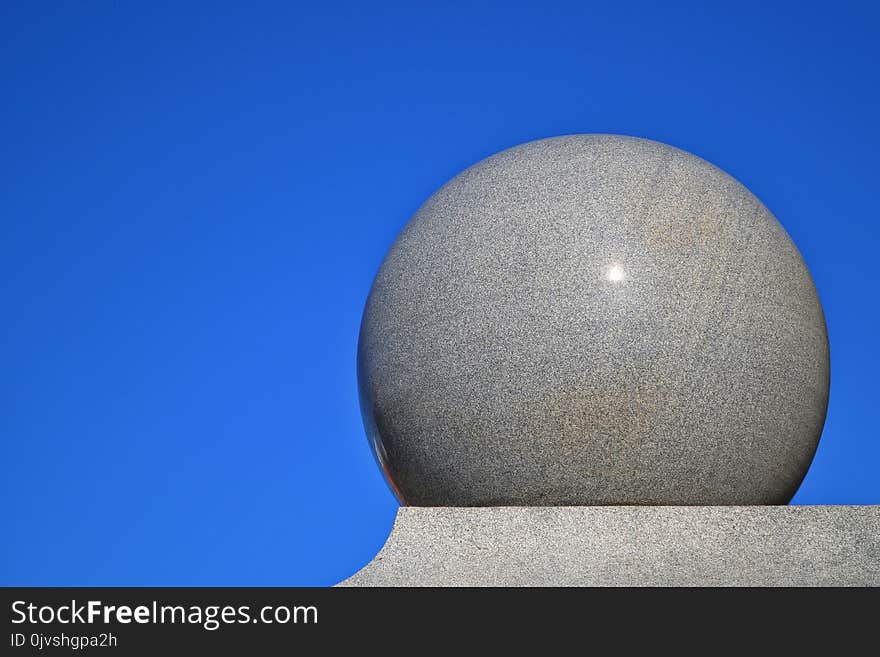 Gray Ball on Gray Surface With Blue Background