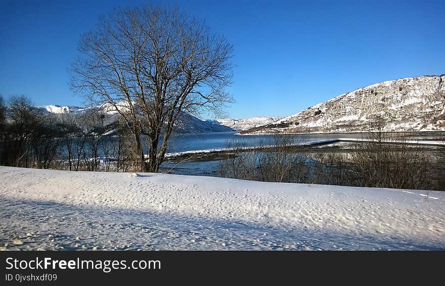 Mountain Across Body of Water Under Clear Blue Sky