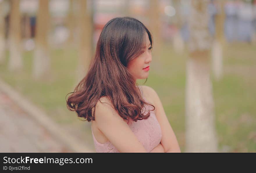 Shallow Focus Photo of Woman in Beige Sleeveless Top