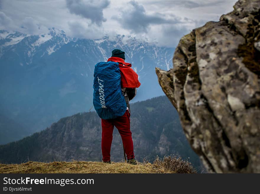 Man Wearing Red Pants on Cliff