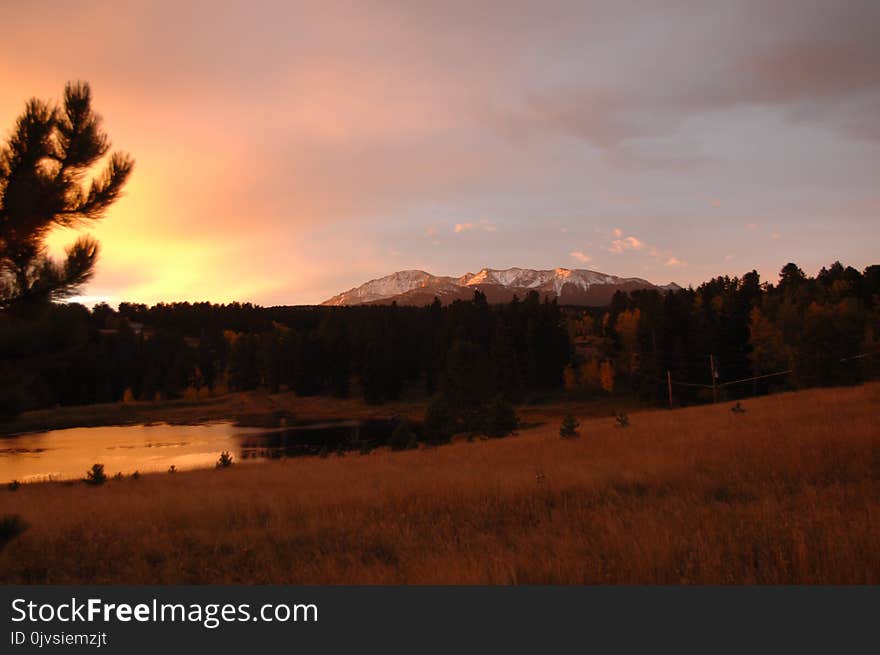 Silhouette Photo of Grass Field With Body of Water and Mountains